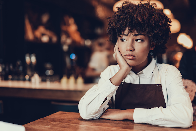 Young lady looking aside and sitting over table