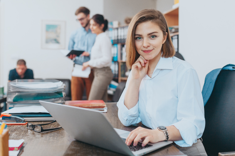 Young female intern reading email at the office